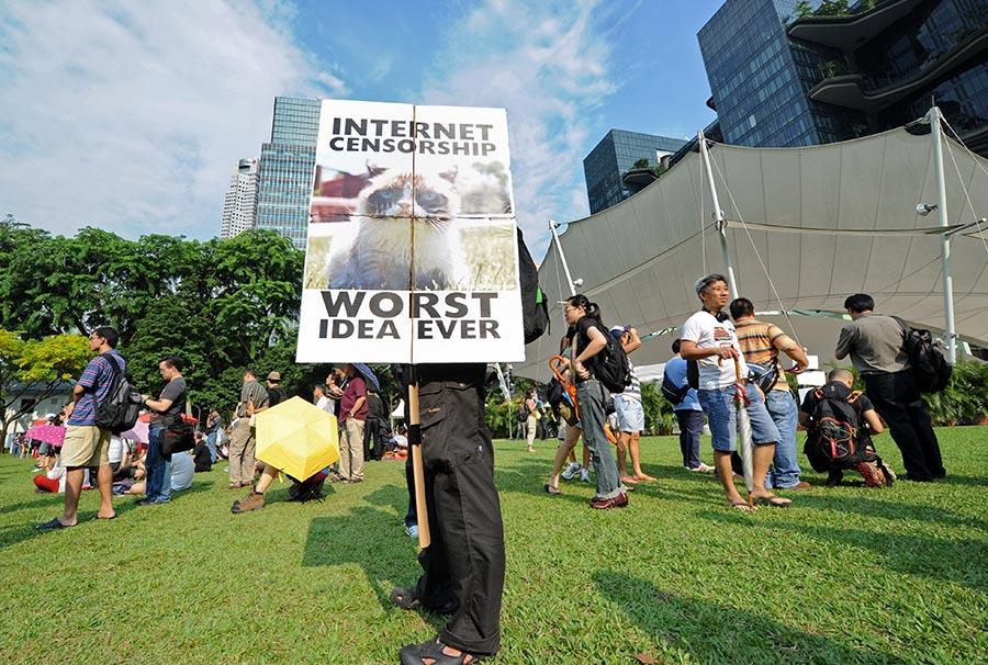 Man holds a Grumpy Cat sign protesting internet censorship in Singapore